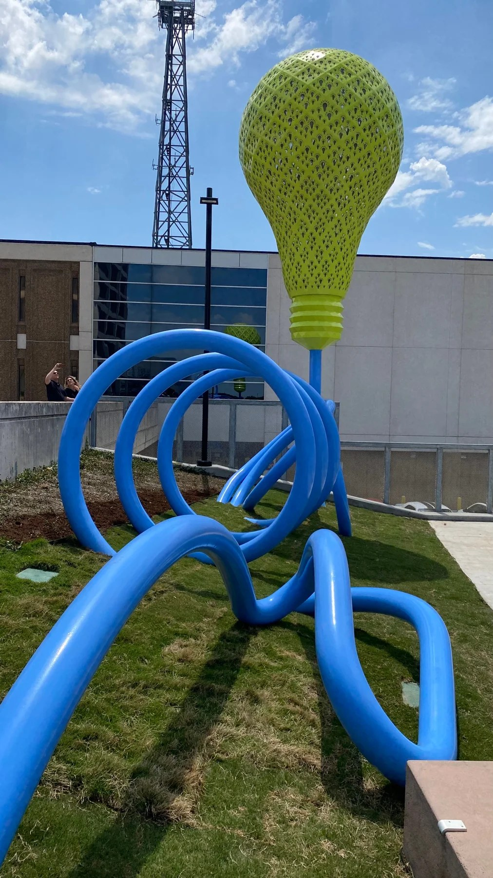 Highlight sculpture — green lightbulb and looping blue cord